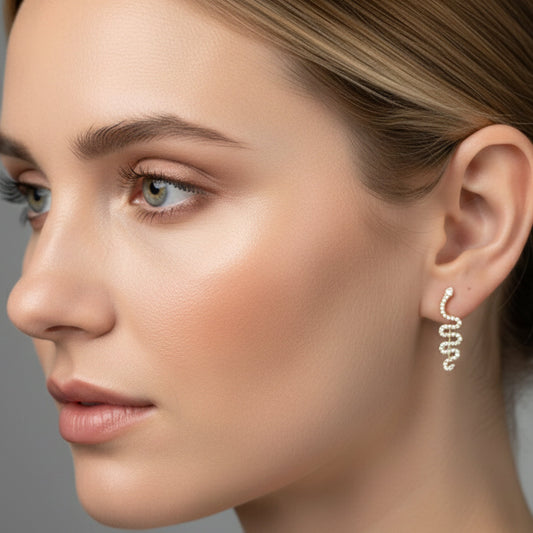 Close-up of a woman wearing a delicate earring against a neutral background