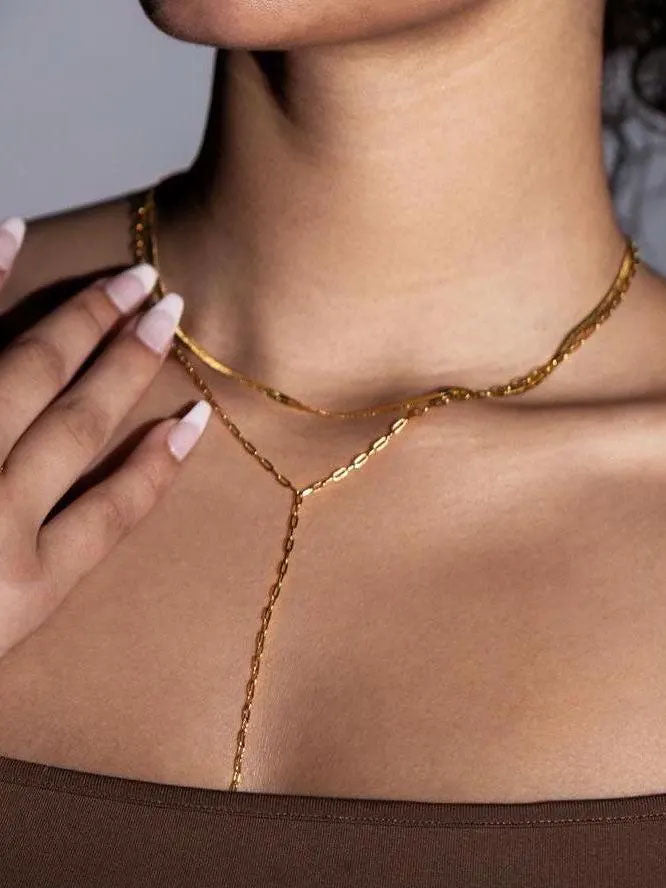 Close-up of a person wearing a gold body chain with a blurred background