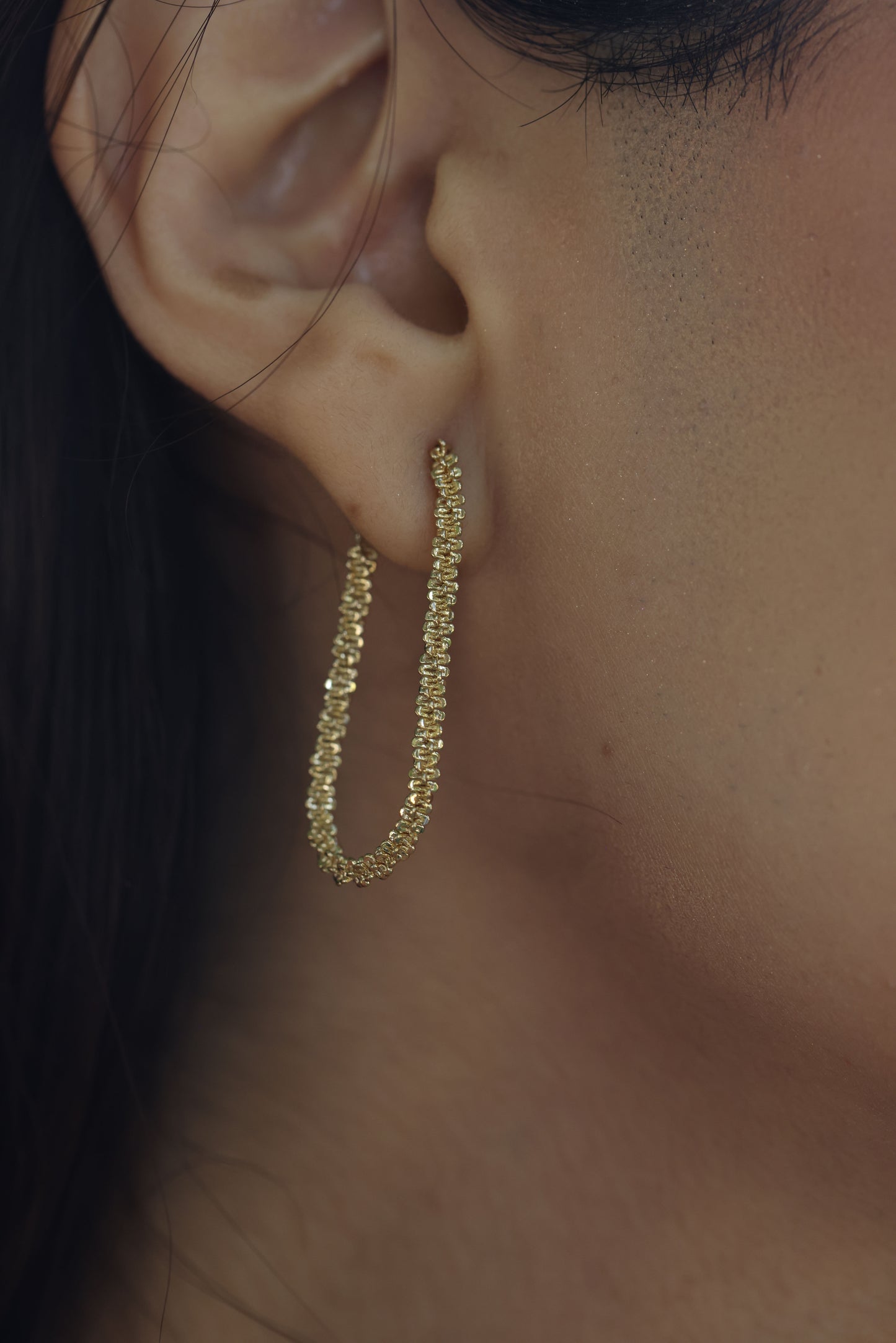 sparkle gold chain errings on a ear