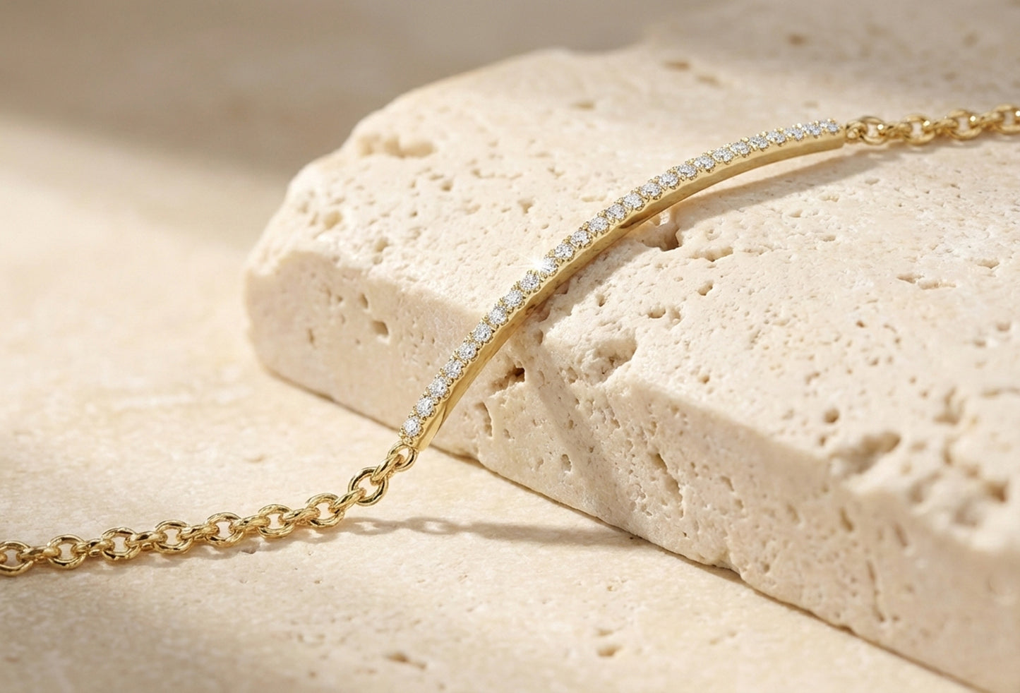 Gold chain necklace on a textured beige surface