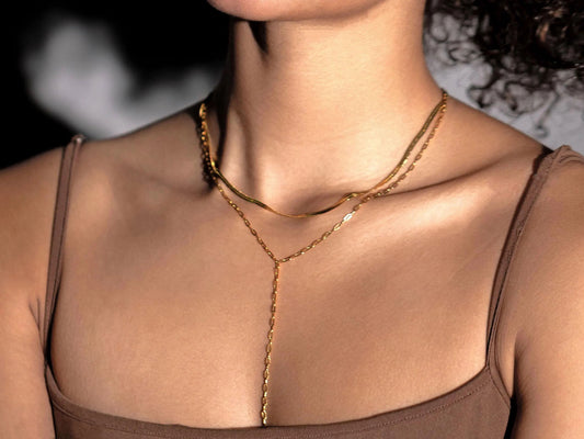 Close-up of a person wearing a gold body chain with a blurred background