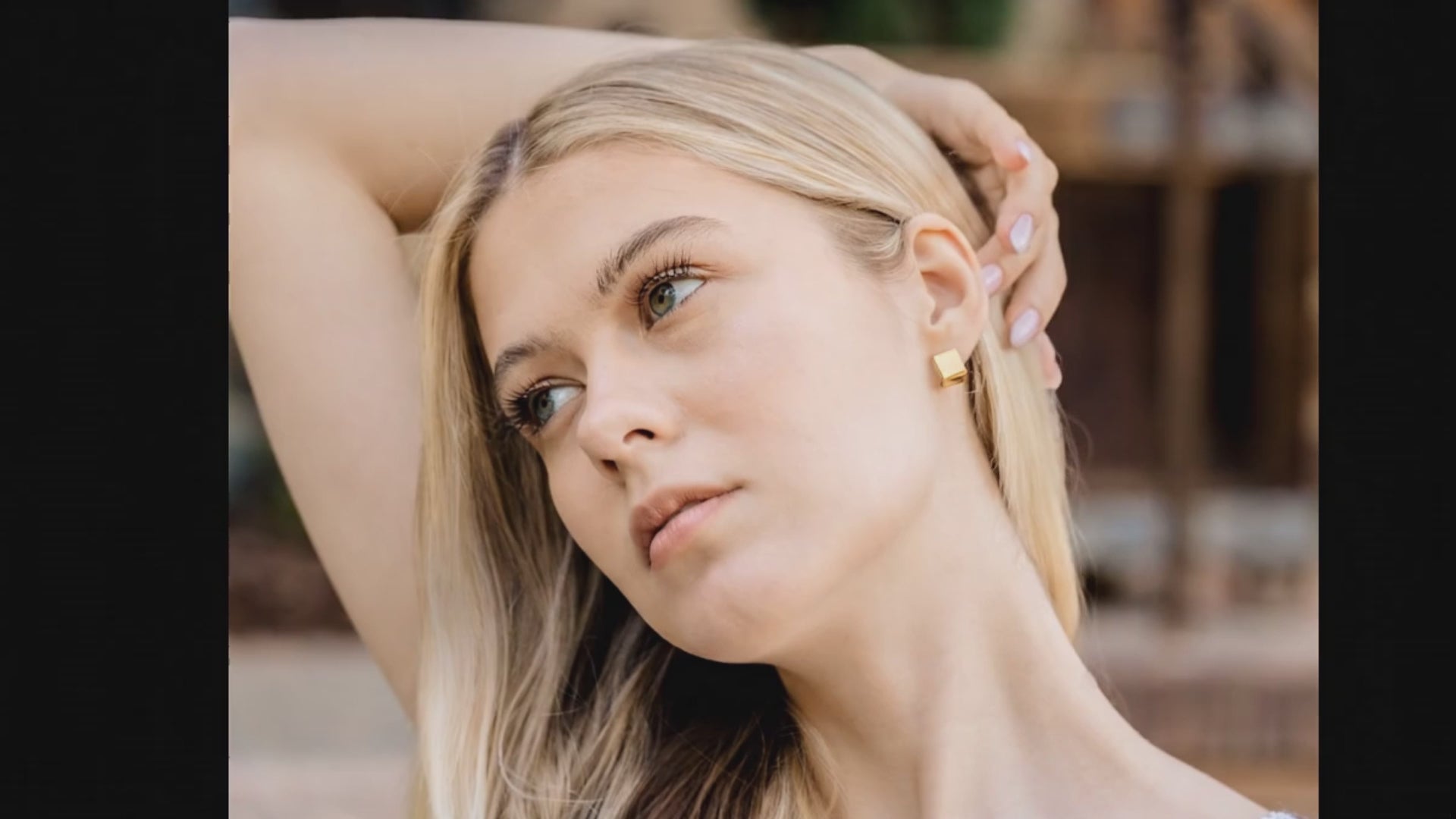 square gold earrings on a blond woman