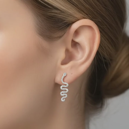 Close-up of an ear wearing a small  snake earring 