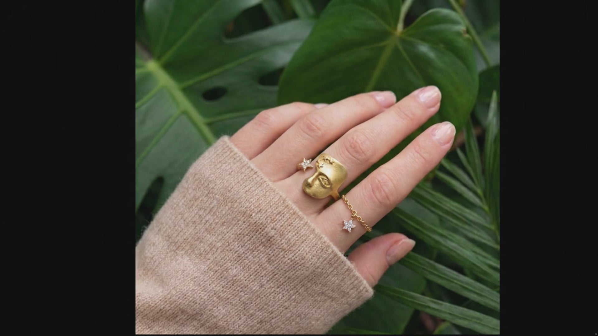 gold face ring on a hand with a jungle background