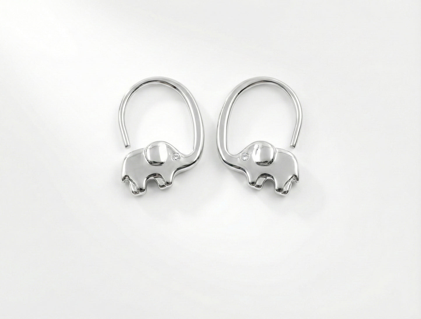 Pair of silver elephant-shaped earrings on a white background