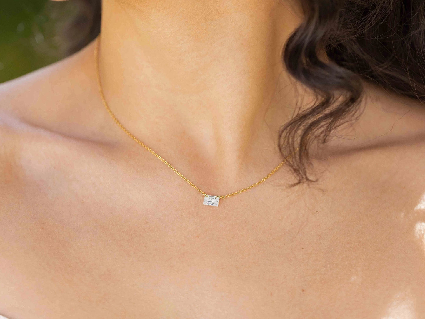 woman with  an emerald cut zircon with a gold chain